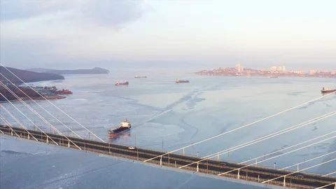 Flying sideways, aerial view of Russian bridge road with driving cars. Sunrise Видео 102583353