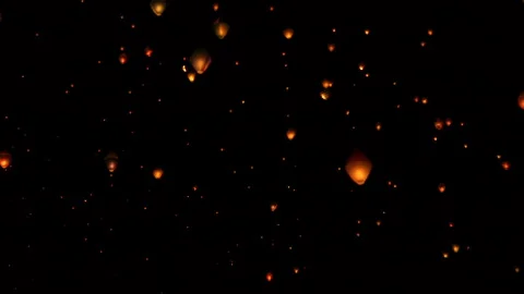 Flying Sky Lanterns fly across the dark sky Stock Footage 135767462