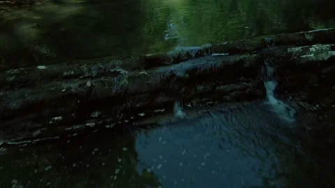 Flying slowly and low on a drone along the river from the waterfall among the Stock Footage 235339294