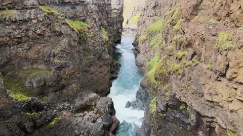 Flying slowly through a canyon with a river flowing below, 4K Video stock 138314302