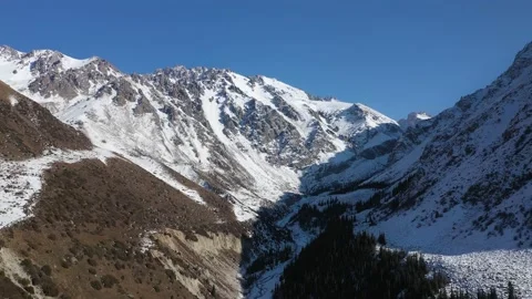 Flying in a snowy mountain valley 動画素材 234081604
