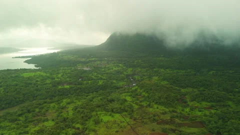 Flying into storm clouds over green Sahyadri basin with glittering river &amp; Stock Footage 346011476