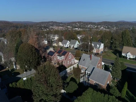 Flying straight at tree level close to rooftops in Bristol CT Stock Footage 82327684