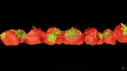 Flying strawberries infront of black background in slowmotion Stock Footage 163216358