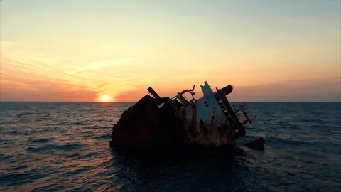 Flying to the Sunken ship above the ocean, aerial shot during sunset Stock Footage 90070583