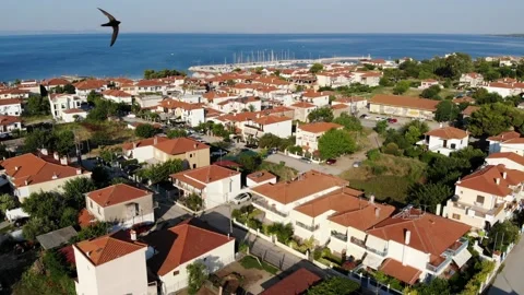 Flying with swallows over the red tile roof houses in Nikiti - resort city on Si Stock Footage 160549771