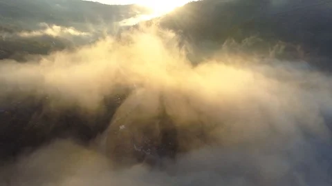 Flying through beautiful sunny cloudscape in the mountains at sunrise. Aerial Stock-Footage 119471424