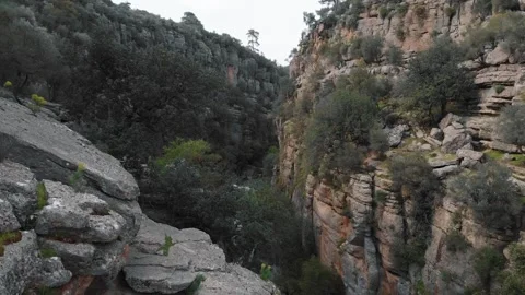 Flying through the Canyon with a blue river. Drone move forward in cliffs Stock Footage 248461602