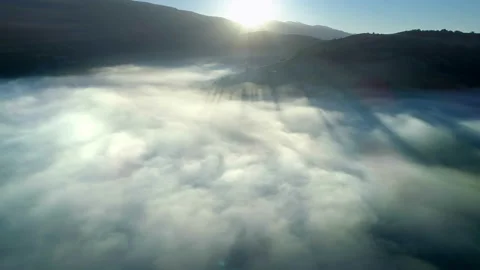 Flying through the clouds above mountain tops. High peaks wonderful morning Stock-Footage 99394857