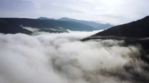 Flying through the clouds above mountain tops. High peaks wonderful morning Stock Footage 169369288