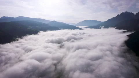 Flying through the clouds above mountain tops. High peaks wonderful morning Stock Footage 169369599