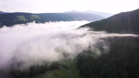 Flying through the clouds above mountain tops. High peaks wonderful sunrise Stock Footage 169369721