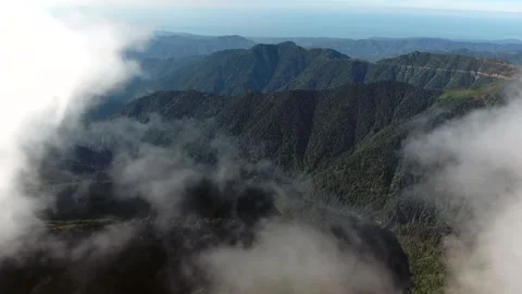 Flying through clouds above untouched forested valleys - Terrain and Mist Scene Stock Footage 339373816