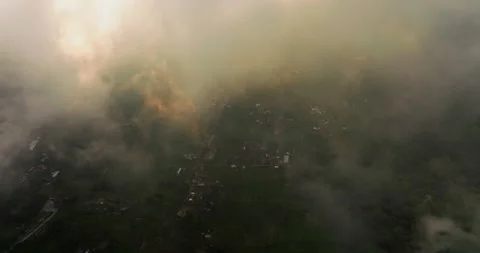 Flying through clouds during sunset light over Munduk village in Bali Stock Footage 248596116