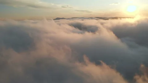 Flying through the clouds at dusk or dawn. Flying in pink clouds in the sun Stock Footage
