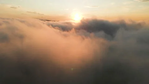 Flying through the clouds at dusk or dawn. Flying in pink clouds in the sun Stock Footage 96553016