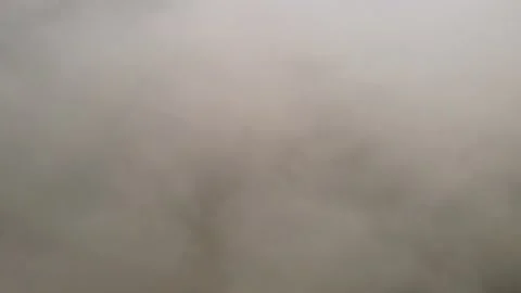 Flying through the clouds. The mountain range shines through the gray clouds Stock Footage 168163645