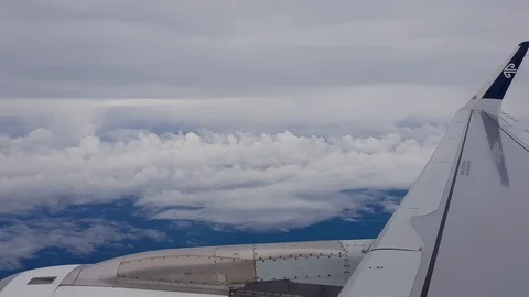 Flying through clouds over a blue sea on air New Zealand 库存影片 86881374