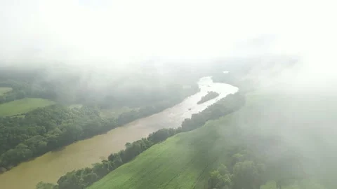 Flying through the clouds over green fields, forest and river. Fog. Misty. Stock Footage 233218490