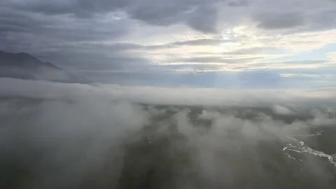 Flying through the clouds over the mountain valley at dawn. Aerial view. Vídeo Stock 170043654
