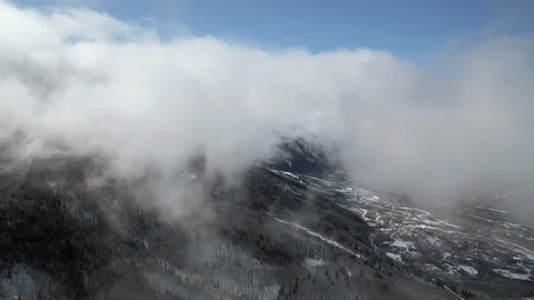Flying through clouds over Powderhorn mountain resort high in the mountains Stock Footage 123884282