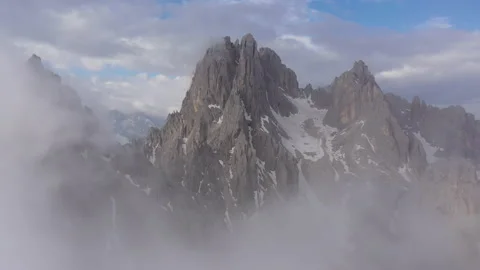Flying through clouds reveals jagged peaks of Dolomites mountain ranges Italy Stock Footage