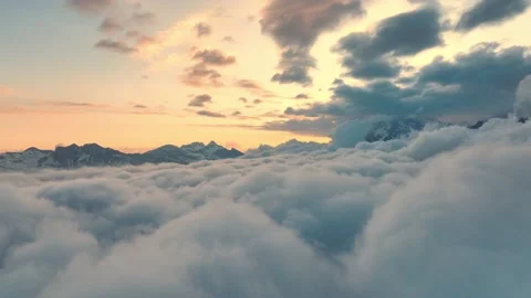 Flying through clouds at sunrise in the Alps, peaceful morning in winter Stock Footage 221736723