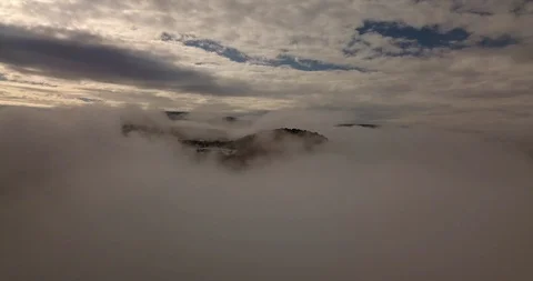Flying through clouds toward red mountain tops in winter Stock Footage 101902033