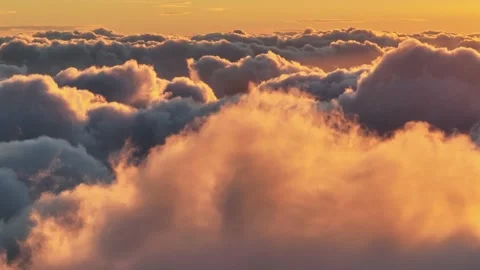 Flying through dense orange clouds illuminated by the setting sun. Gorgeous Stock Footage 169147948