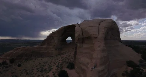 Flying through enormous stone arch with stormy skies in the desert of Utah Stock Footage 111406519