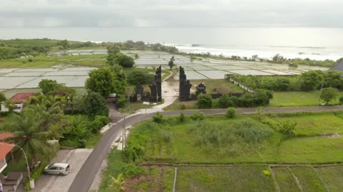 Flying through the gates of Bali Temple, near rice fields, aerial video Stock Footage 134761863