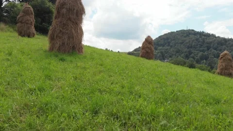 Flying through haystacks in mountain fields Stock Footage 139732546