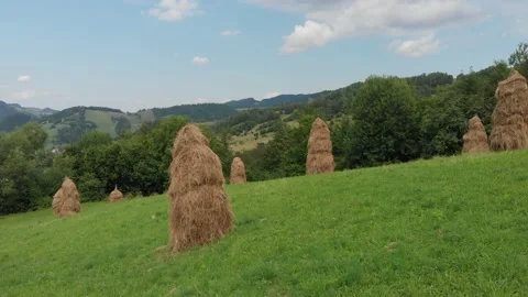 Flying through haystacks in mountain fields Stock Footage 139732659