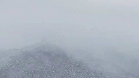 Flying Through Heavy Snowfall with Low Visibility Over Snowy Mountains Stock Footage 344247900