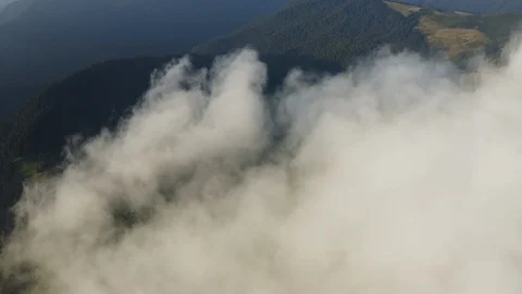 Flying through light clouds above the mountains drone footage Stock Footage 121146162