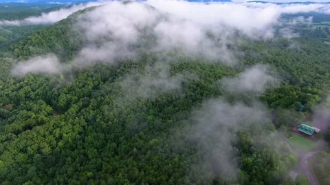 Flying through low white clouds above green forest of the Great Smoky Stock Footage 133899006