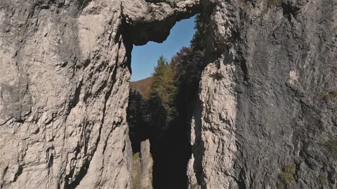 Flying Through Natural Rock Window in Autumn Forest Mountains Stock Footage 311505451