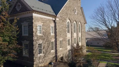Flying through old historic stone church building on sunny fall day 4k drone Stock Footage 241833548
