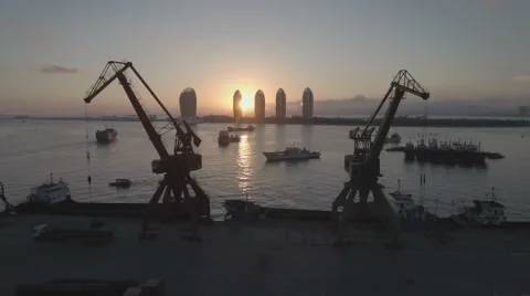 Flying through old rusty cargo cranes in a small port at sunset in Sanya, China Stock-Footage 67528239