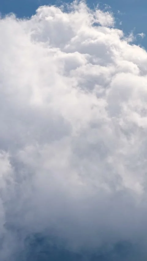 Flying through white fluffy clouds in blue sky during a flight Stock Footage 341446466