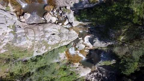 Flying from the top to the bottom of a waterfall. Overhead view. Video stock 152033683