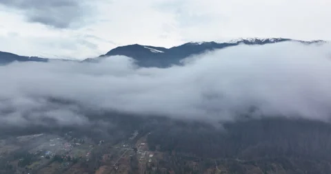 Flying on top of the clouds discovering the mountains with snow on the peak. Stock Footage 174345200