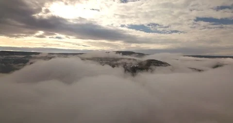 Flying toward mountains peeking through dense foggy clouds Stock Footage 101901495