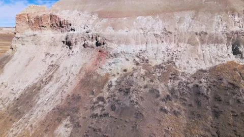 Flying towards colored bluff in badlands Stock Footage 306091673