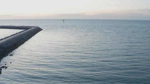 Flying towards container pickle in the noth sea from the beach and pier Stock Footage 123022756