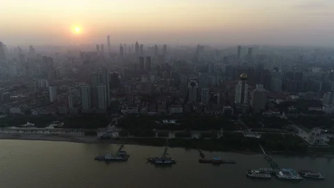 Flying towards downtown Wuhan city at sunset, massive metropolis in China Stock Footage
