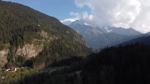 Flying towards a narrow valley in the shadow. Mountain range in the background. Video stock 152047292