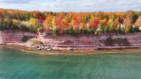 Flying Towards Red Cliffs and Vibrant Autumn Colors Aerial on Lake Superior Stock Footage 315265674