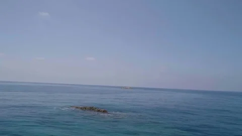 Flying towards a rock with birds in the middle of the ocean Video stock 80602700