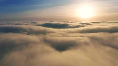 Flying towards the Sun above the clouds with beautiful golden clouds at sunrise Stock Footage 229608067